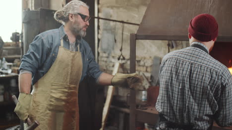 Two-Blacksmiths-Working-Together-in-Forge